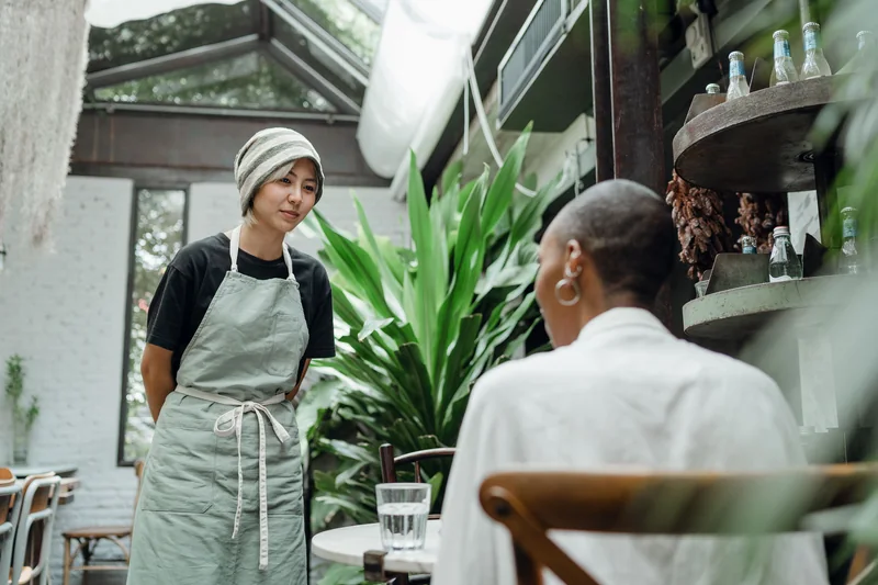 Adult customer and server having a café conversation